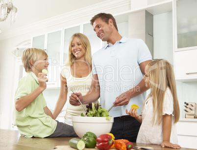 Familie bereitet Salat zu