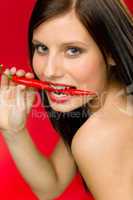 Chili pepper - portrait young woman bite red spicy