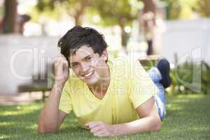 Portrait Of Teenage Boy Laying In Park