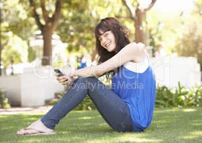 Portrait Of  Teenage Girl Sitting In Park