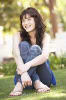 Portrait Of  Teenage Girl Sitting In Park