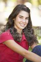 Portrait Of  Teenage Girl Sitting In Park