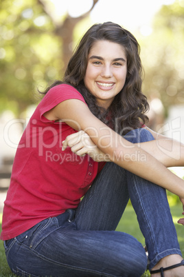 Portrait Of  Teenage Girl Sitting In Park