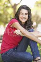 Portrait Of  Teenage Girl Sitting In Park