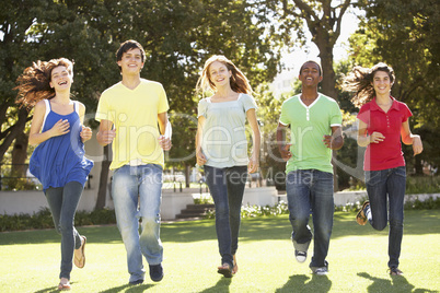 Group Of Teenagers Running Through Park