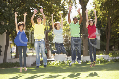 Group Of Teenagers Jumping In Air In Park