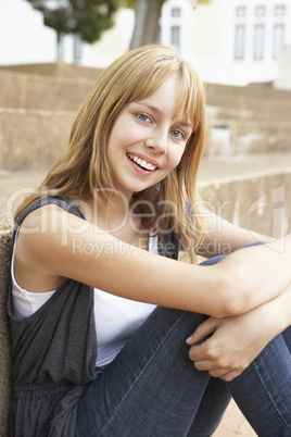 Smiling Teenage Student Sitting Outside On College Steps