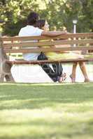 Couple Sitting Together On Park Bench