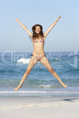 Frau springt am Strand