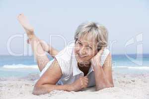 Seniorin liegt am Strand
