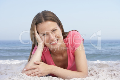 Frau liegt am Strand