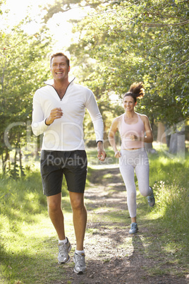 Middle Aged Couple Jogging In Park