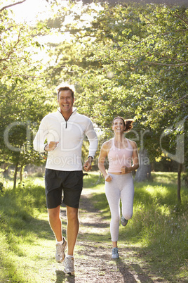 Middle Aged Couple Jogging In Park