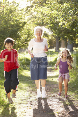Grandmother Jogging In Park With Grandchildren