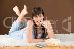 Woman teenager watch television eat popcorn