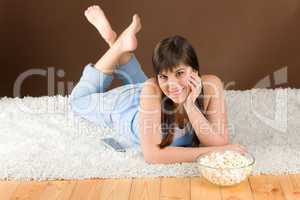 Woman teenager watch television eat popcorn