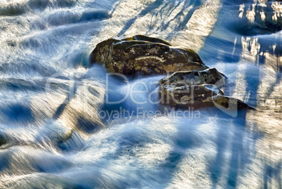 Raging river flows around rocks