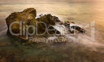 Long exposure sunset on sea rocks