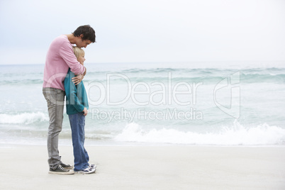 Father And Son Standing On Winter Beach Together