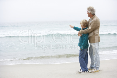 Grandfather And Son Standing On Winter Beach Together