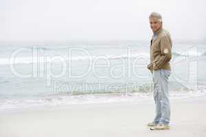 Senior Man On Holiday Standing On Winter Beach