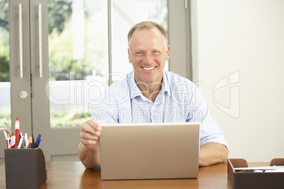 Middle Aged Man Using Laptop At Home