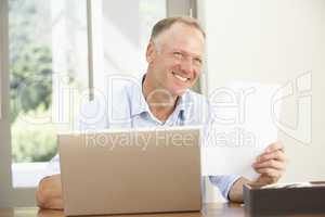 Middle Aged Man Using Laptop At Home