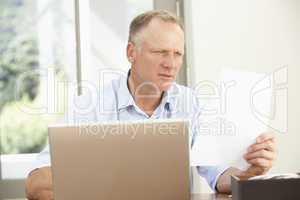 Middle Aged Man Using Laptop At Home