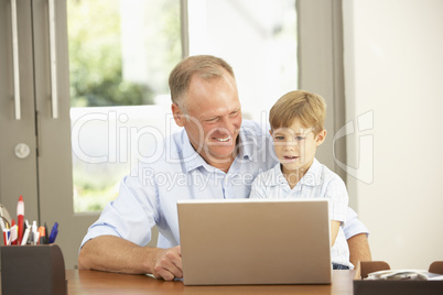 Father And Son Using Laptop At Home