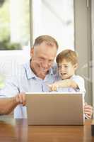 Father And Son Using Laptop At Home