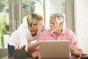 Adult Daughter And Senior Father Using Laptop At Home