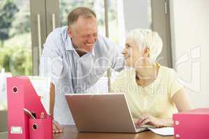 Adult Son And Senior Mother Using Laptop At Home