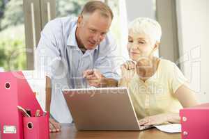 Adult Son And Senior Mother Using Laptop At Home