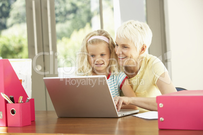 Granddaughter And Grandmother Using Laptop At Home