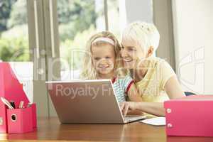 Granddaughter And Grandmother Using Laptop At Home