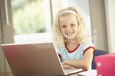 Young Girl Using Laptop At Home