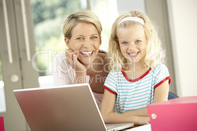 Mother And Daughter Using Laptop At Home