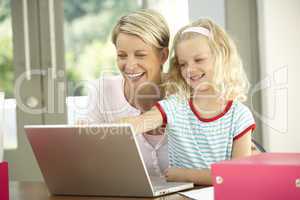 Mother And Daughter Using Laptop At Home