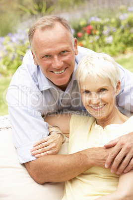 Senior Woman And Adult Son Relaxing In Garden