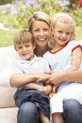 Mother And Children Relaxing In Garden