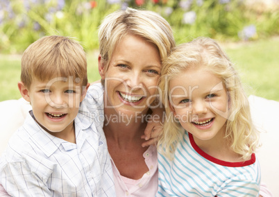 Mother And Children Relaxing In Garden