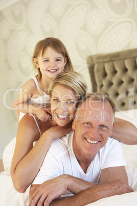 Family Relaxing In Bedroom