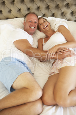 Couple Relaxing In Bedroom