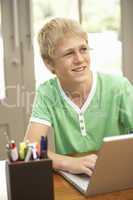 Teenage Boy Using Laptop At Home