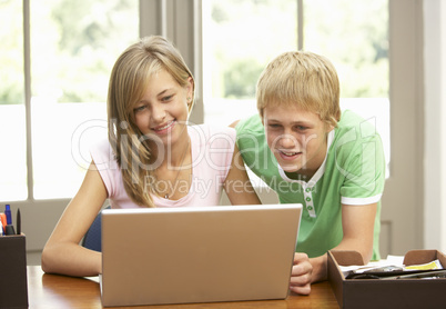 Two Teenagers Using Laptop At Home