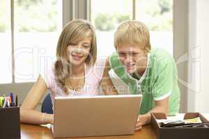 Two Teenagers Using Laptop At Home