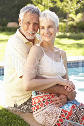 Senior Couple Relaxing By Pool In Garden