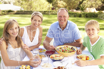 Family Enjoying Meal In Garden