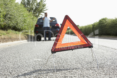 Driver Broken Down On Country Road With Hazard Warning Sign In F