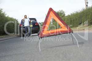 Driver Broken Down On Country Road With Hazard Warning Sign In F